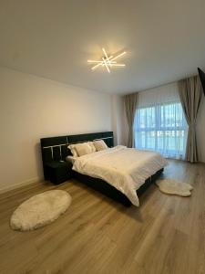 a bedroom with a large bed and two rugs at Luxury Vibes in Şelimbăr