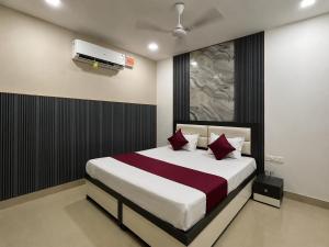 a bedroom with a large bed with red pillows at Hotel Triple A in Bhucho