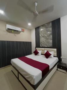a bedroom with a large bed with red pillows at Hotel Triple A in Bhucho