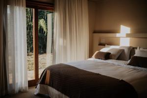 a bedroom with a large bed and a large window at Villa Arouca in Areal