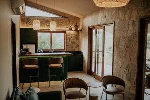 a kitchen with a green counter and chairs at Villa Arouca in Areal
