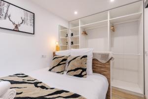 a white bedroom with a bed and a mirror at Les Caribous - Lac 1 min, Espace Diamant, Megeve in Praz-sur-Arly