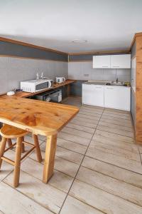 a kitchen with a wooden table and a counter top at Apart Hotel y Cabañas Valle Exploradores in Puerto Tranquilo +32 photos