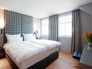 ein Schlafzimmer mit einem großen Bett mit weißer Bettwäsche in der Unterkunft Boutique Apartments Bezau in Bezau