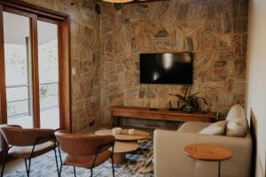 a living room with a couch and a tv on a wall at Villa Arouca in Areal