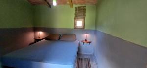 una camera da letto con un letto e due lampade su due tavolini di back to nature basic camping hut Casa Biron a Pietralunga