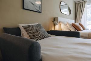 a bedroom with two beds and a couch and a window at Apartment in Engelberg in Engelberg +14 photos