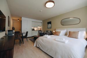 a bedroom with a large white bed and a living room at Apartment in Engelberg in Engelberg