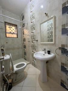 a bathroom with a toilet and a sink at Ocean Cliff Homes 4 bedroom shared apartment in Mombasa +18 photos