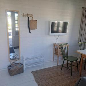 a living room with a tv and a table and chairs at Gästhus öppen planlösning in Oskarshamn