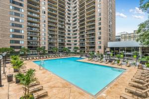 an overhead view of a swimming pool with chairs and a large building at Stylish Apt in Crystal City in Arlington