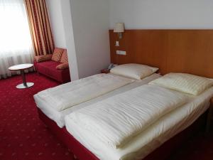 A bed or beds in a room at Hotel Wirt im Feld