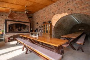 a dining room with a table and a brick wall at Bogdanović Winery Apartman in Ilok