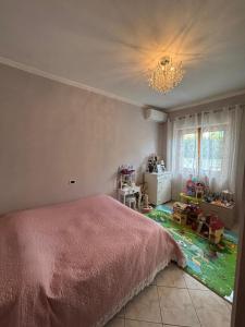 a bedroom with a pink bed and a chandelier at Villa Severino Ferrari in Anzio in Anzio