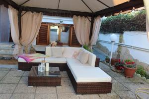 a white couch sitting under an umbrella on a patio at Villa Severino Ferrari in Anzio in Anzio
