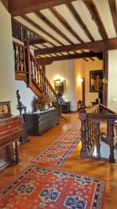 a living room with a staircase and a rug at Hotel Altamira in Santillana del Mar
