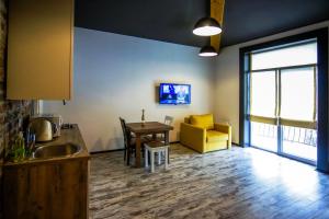 a kitchen and dining room with a table and a yellow couch at Potocki Apartments in Lviv