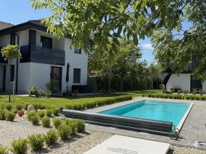 a swimming pool in front of a house at Minimál Éden in Balatonlelle