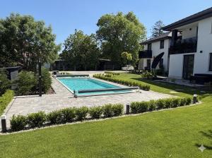 a swimming pool in a yard next to a house at Minimál Éden in Balatonlelle +4 photos