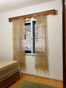 a bedroom with a window with curtains on it at Green House in Pogradec