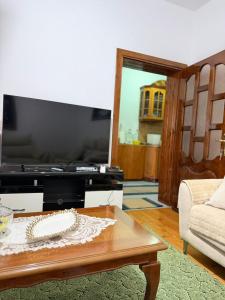 a living room with a coffee table and a tv at Green House in Pogradec