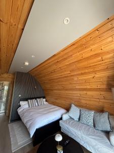 two beds in a room with a wooden wall at Celtic Glamping in Limerick
