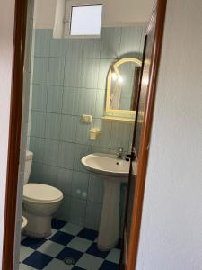 a bathroom with a sink and a toilet and a mirror at Green House in Pogradec