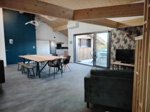 a dining room with a table and chairs and a television at Le p'timyno in Moncoutant