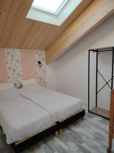 a bedroom with a bed in a room with a skylight at Le p'timyno in Moncoutant