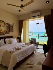 a bedroom with a bed with a view of the ocean at Hotel Beach Castle in Arugam Bay