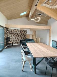 a dining room with a large wooden table and chairs at Le p'timyno in Moncoutant