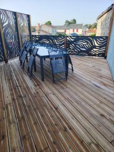 a wooden deck with a table on a balcony at Le p'timyno in Moncoutant