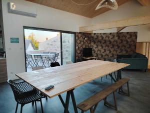 a large wooden table in a living room with chairs at Le p'timyno in Moncoutant +13 photos
