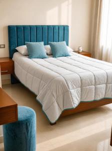 a bedroom with a large bed with a blue headboard at Tarija Premium Stay Apartamento Premium in Tarija