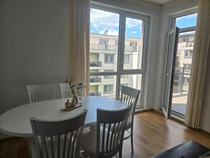 a dining room with a table and chairs and a large window at Artea Hisarya in Hisarya