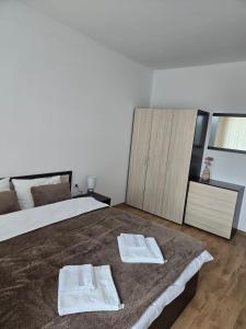 a bedroom with a large bed with towels on it at Artea Hisarya in Hisarya