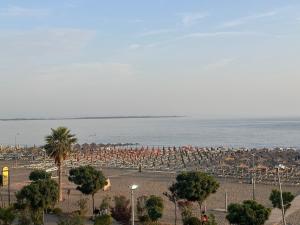 a beach with a lot of umbrellas and the ocean at Vila Era in Shëngjin