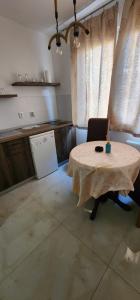 a kitchen with a table in the middle of a room at mala Atina in Petrovaradin +2 photos