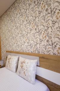 a bedroom with a bed with a floral wallpaper at Casa da Goreti in Armamar