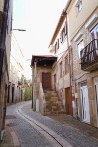 an alley with a building with a wooden door at Casa da Goreti in Armamar