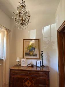 a chandelier hanging over a wooden dresser in a room at Via Belvedere 50 in Montefalco