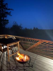 a fire pit on a deck with a table at Celtic Glamping in Limerick