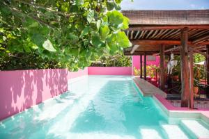 a swimming pool in a backyard with a pink and blue house at La Zebra Tulum, a Small Luxury Hotel in Tulum