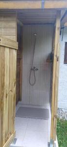 una doccia con tubo flessibile in una struttura di legno di back to nature basic camping hut Casa Biron a Pietralunga