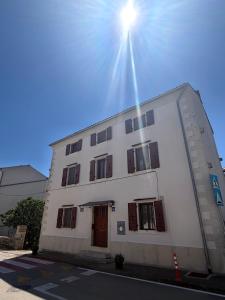 a white building with the sun shining on it at Tea Rooms III in Bale