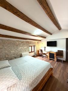 a bedroom with a bed and a stone wall at Tea Rooms III in Bale