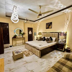 a bedroom with a large bed and a ceiling fan at Charming Home banglow in Karachi