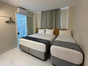 zwei Betten in einem Hotelzimmer mit Fenster in der Unterkunft Viso Hotel in Tianguá + 67 Fotos