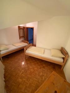 a room with two bunk beds and a wooden floor at Estrada Cazin in Ostrožac +2 photos
