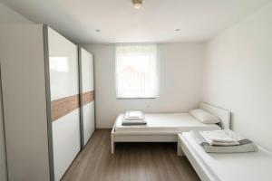 a white room with a bed and a window at STAY - Seeblick Apartment in Friedrichshafen